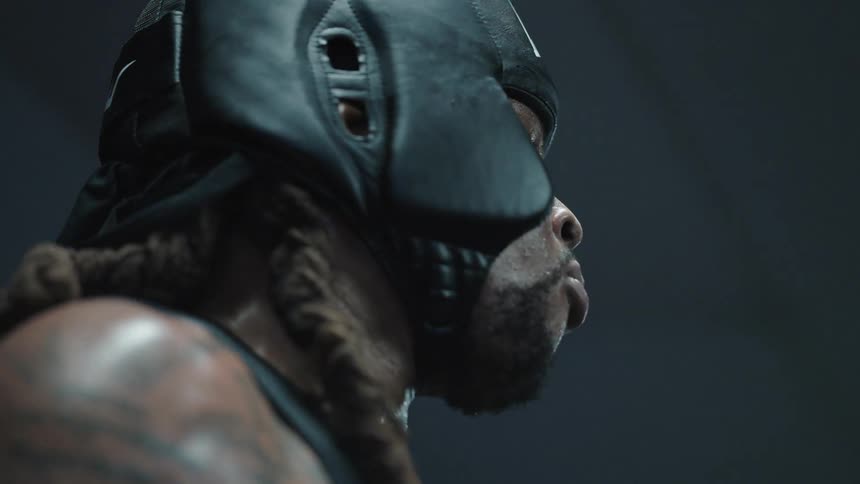 A muscular male boxer inserts his mouth guard before he begins to spar