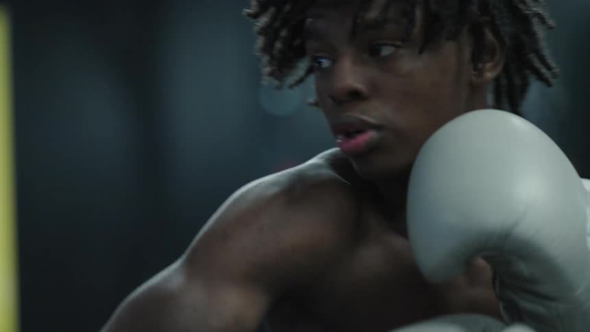 Young boxer with white gloves in a training