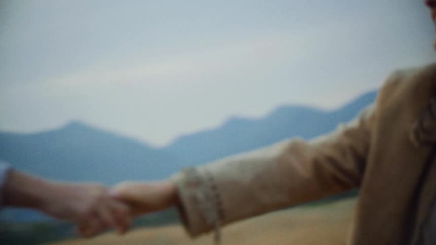 Man and woman holding hands in a spinning field