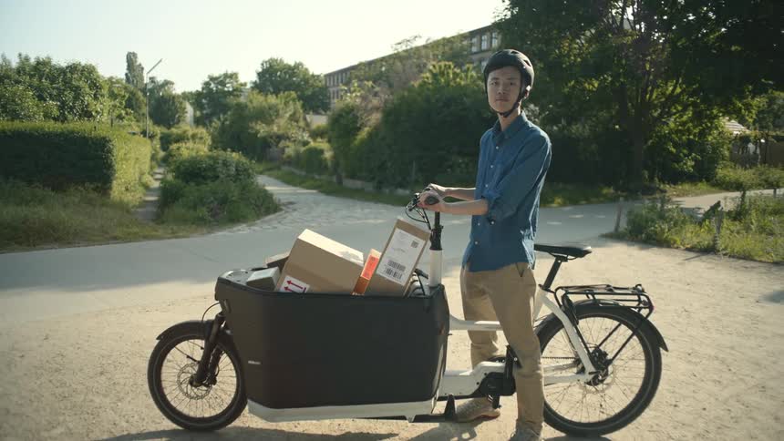 A delivery person is using a bike to deliver packages