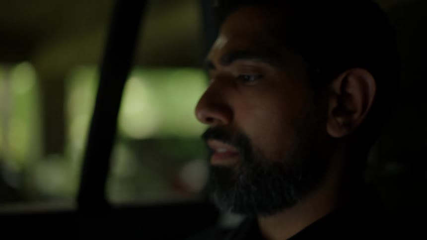 Man with an open laptop while in a moving car