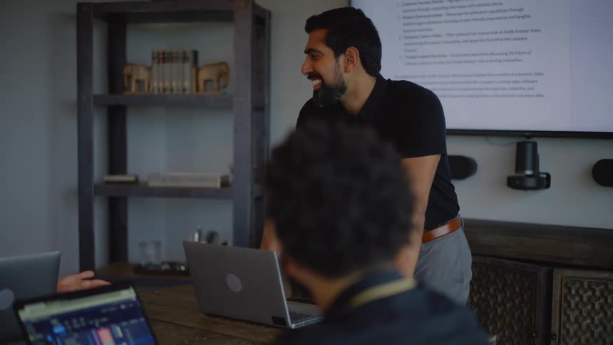 One person presenting on a meeting room to a group of coworkers