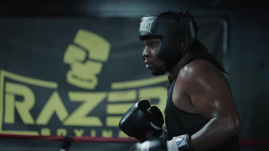Two men in a gym fighting inside a boxing ring