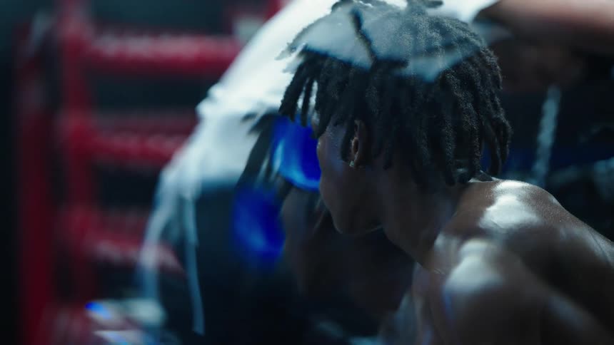 Young man sitting with sweaty body in a boxing ring