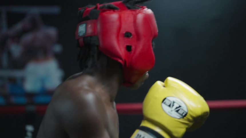 Two young men in a boxing ring training to fight