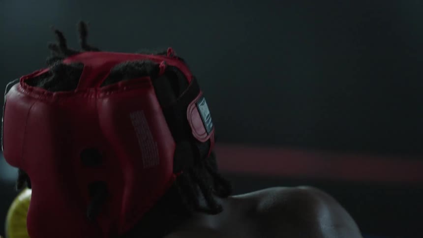 Two men sparring in a boxing ring wearing gloves and headgear