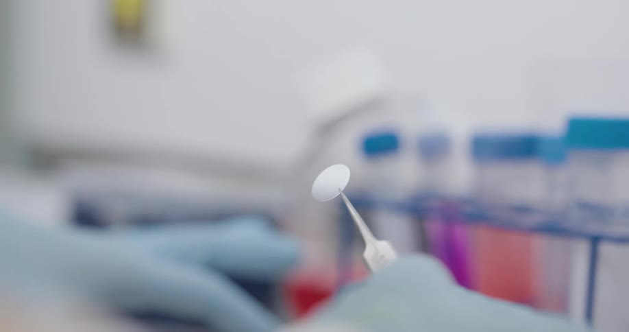 Gloved hands handle cell culture plates