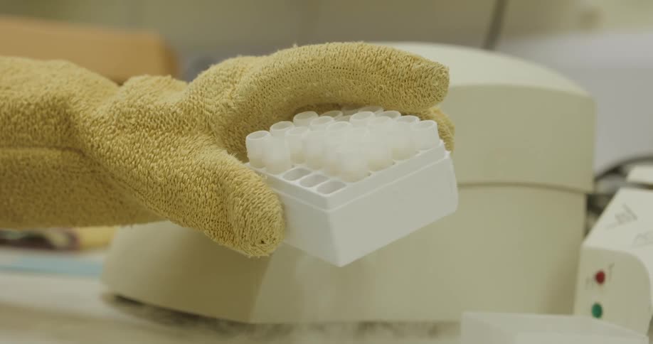 A healthcare professional freezes test tubes with dry ice vapors in a laboratory