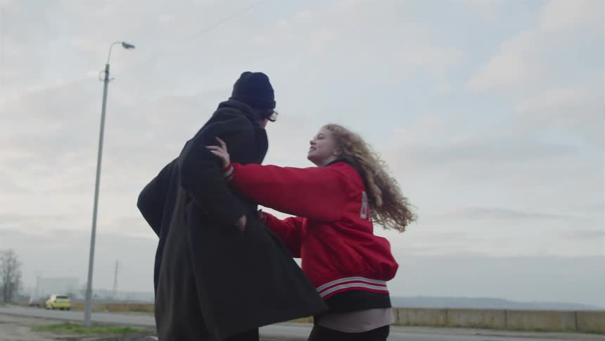 Young woman argues with a man near a rural highway on an overcast fall day
