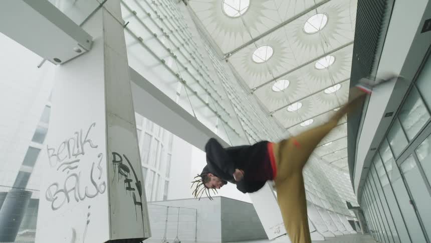 Man performing a somersault in a modern urban environment
