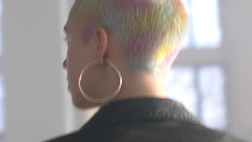 Woman wearing gold earrings and colored hair