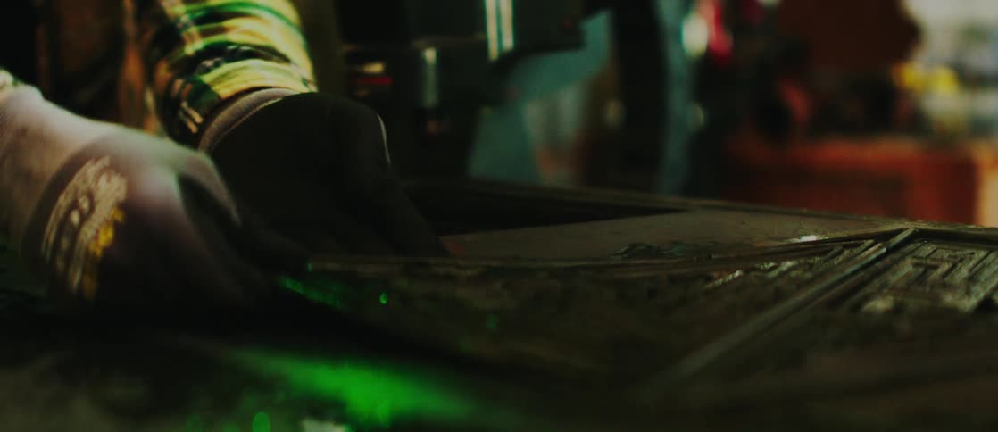 Gloved hands using a tool and removing a plastic plate