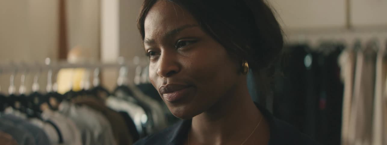 Female clothing store employee smiling in a retail boutique.