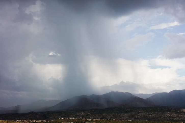 Dark heavy clouds dump rain over a mountain range