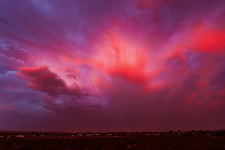 Vibrant sunset with a range of colors from deep purple to bright orange with storm darkening the sky