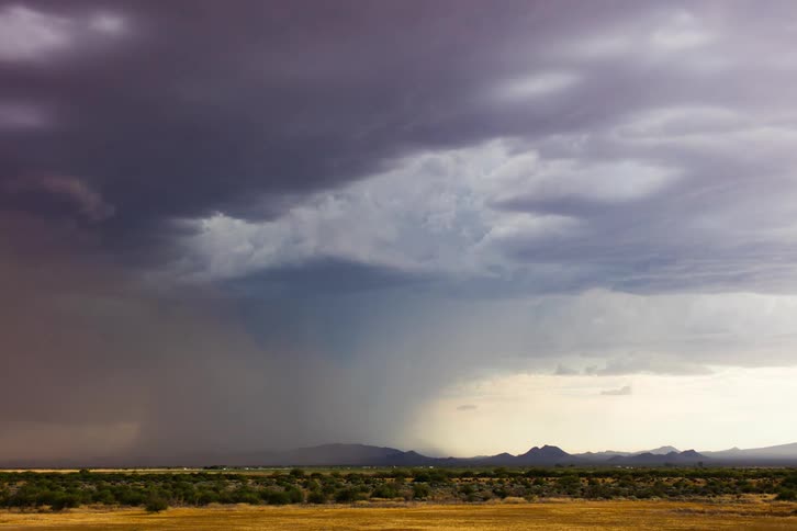 Dark storm clouds gather over a natural landscape