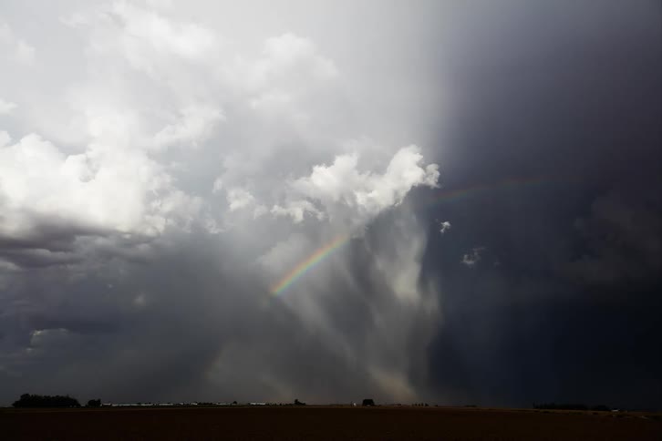 Natural scenery in a cloudy sky with rain and rainbow