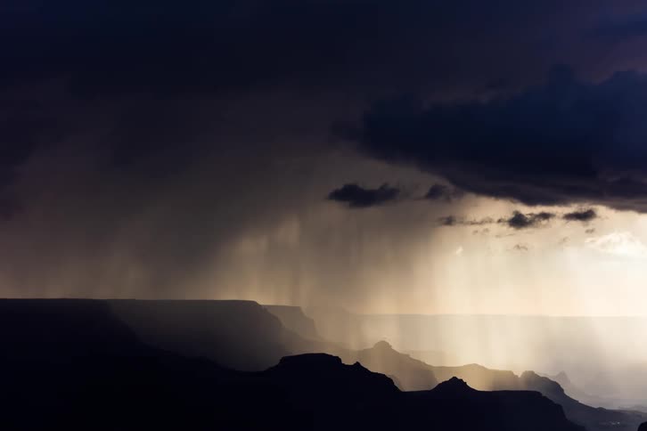 Dark ominous clouds in an impending storm over a mountainous landscape