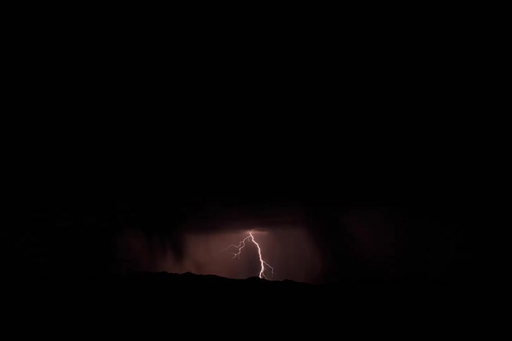 Dark cloudy sky with bursts of thunder and rain