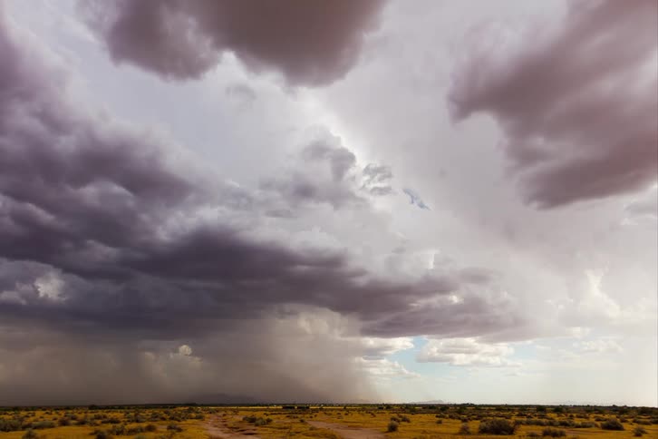 Time lapse of a gust of rain falling over a flat landscape