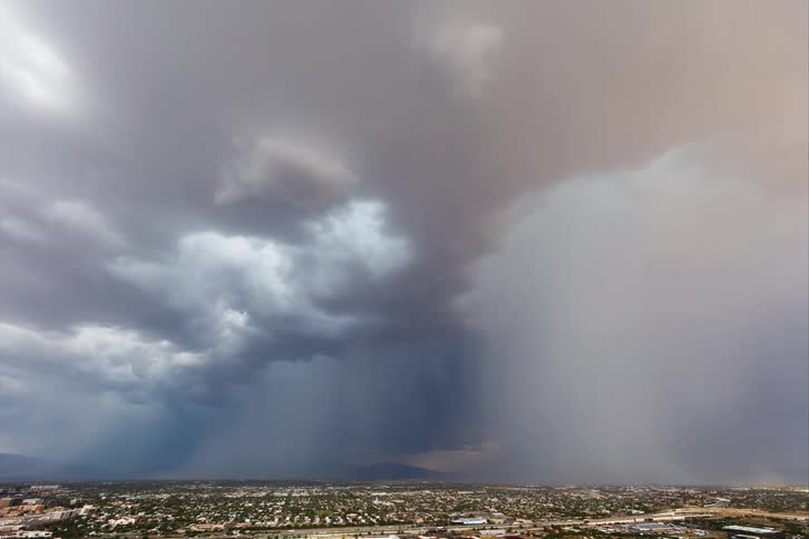 Stormy sky with rain and thunder above an urban city