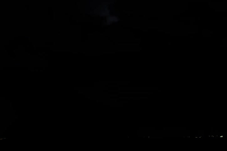 A storm of bright lightning coming out of the sky in a very dark place