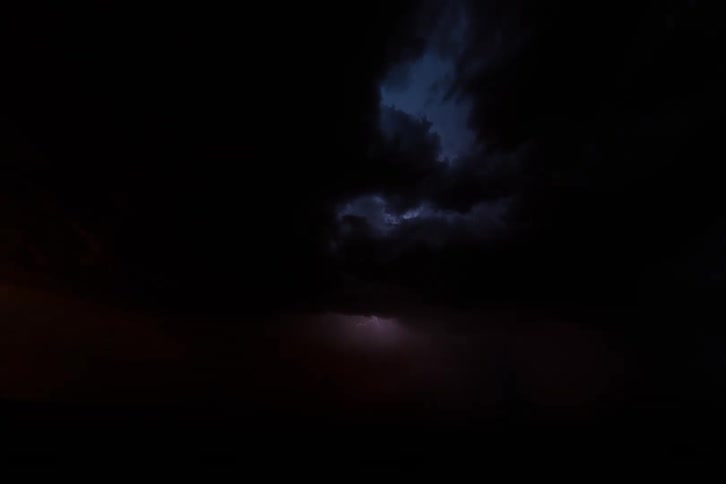 Night storm with lightning illuminating the dark cloudy sky