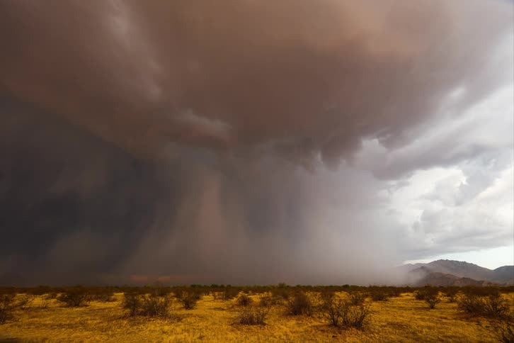 A dense gray cloud forming in a storm in a desert