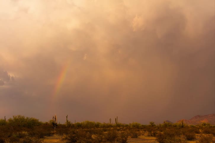 Time lapse of a gust of rain falling over a flat desert landscape