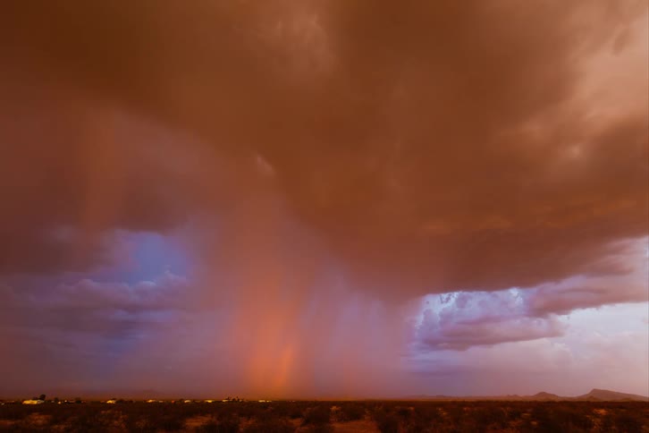 Dark storm clouds loom over a rural landscape