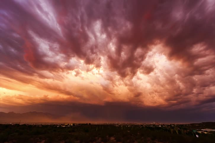 A strong storm of black clouds forming in a darkening sky and then lightning begins to fall