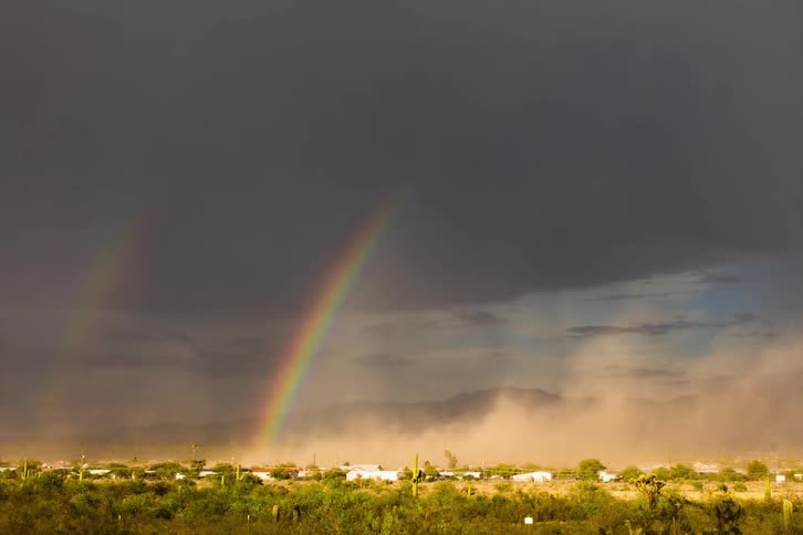 Timelapse of rain and rainbows over a small desert town