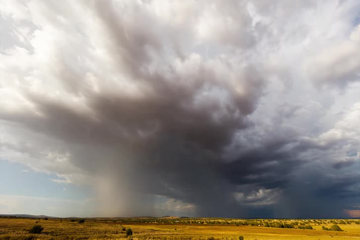 Dramatic sky with dark clouds and rain storm in a field