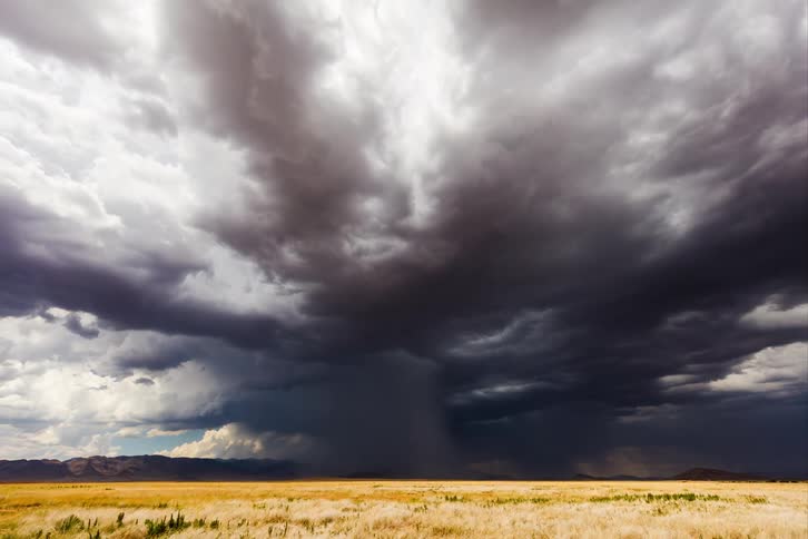 Time lapse of a gust of rain falling over a flat landscape