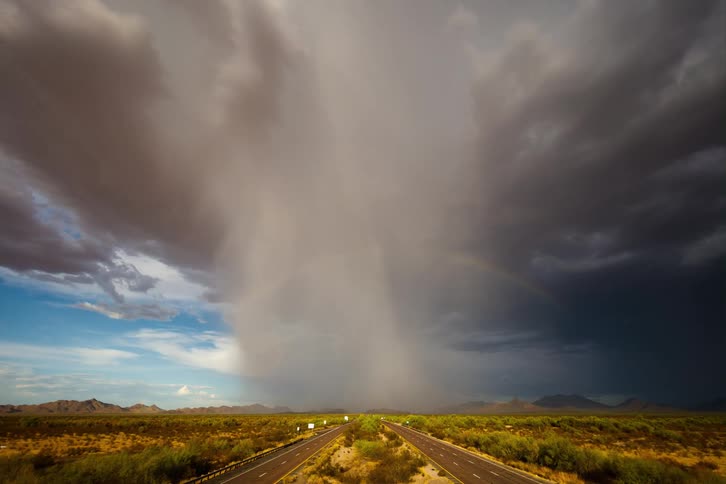 Traffic runs on the highway as a storm rolls in