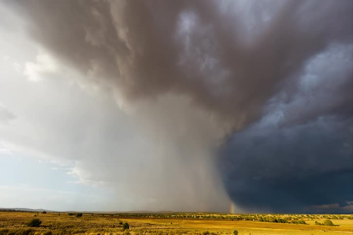 Time lapse of a gust of rain falling over a flat landscape