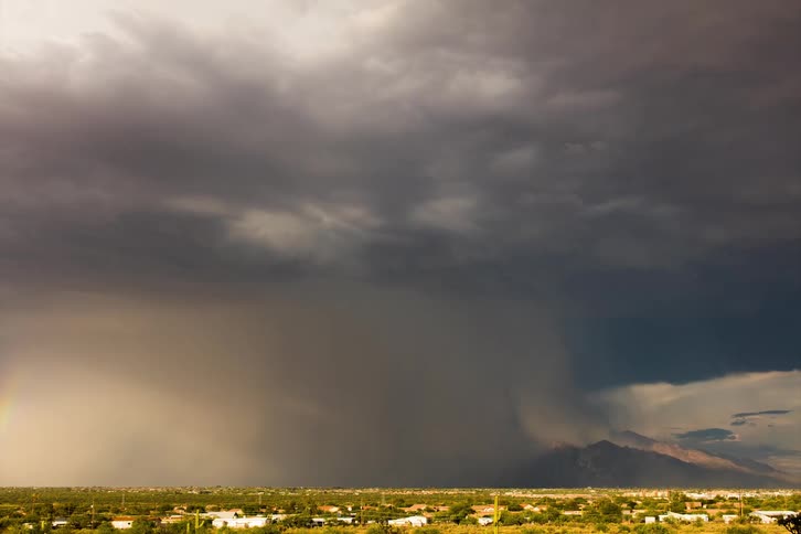 Timelapse of rain and rainbows over a small desert town