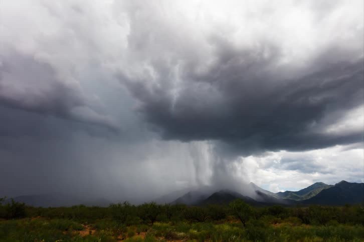 Heavy rain falls across the mountains and plains as a storm front moves across the land