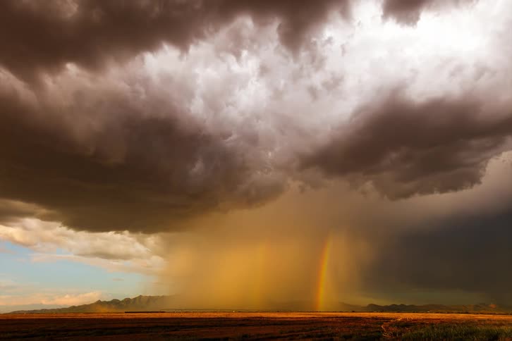 The rain brings a large rainbow