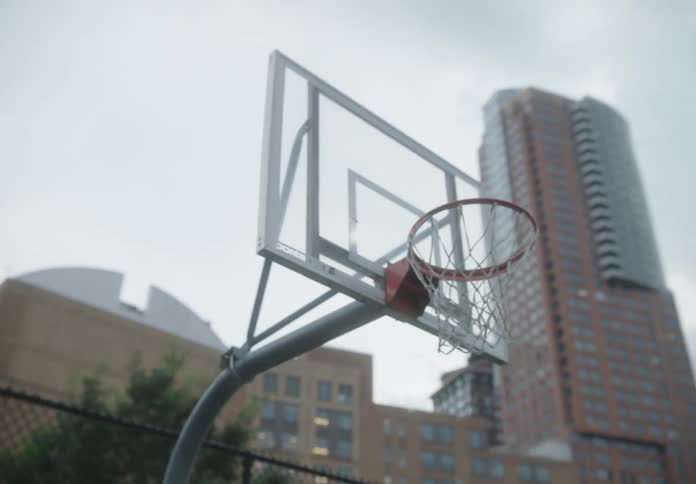 Ball being thrown into a basketball hoop on a court