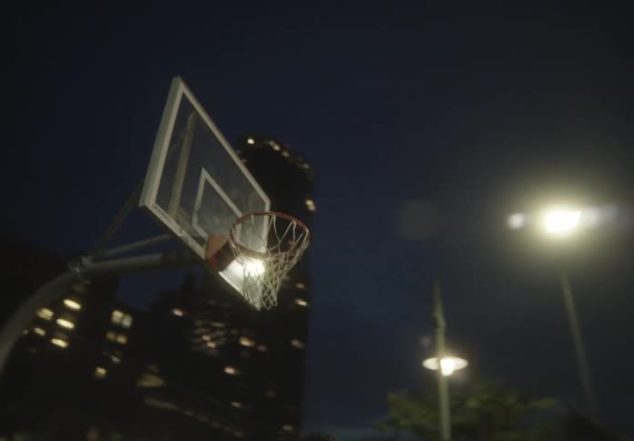 An image of people playing basketball at night