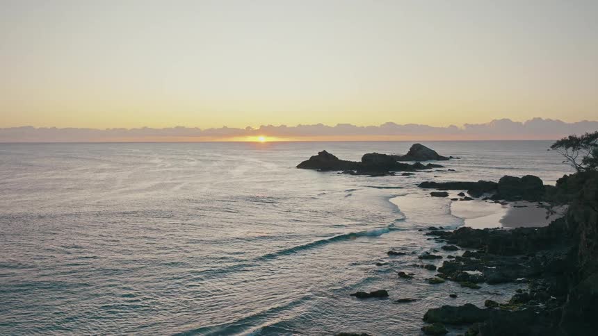 Small waves hit the shore at sunrise