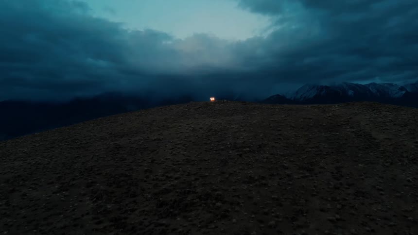 An electrical light on a rocky hill as night falls
