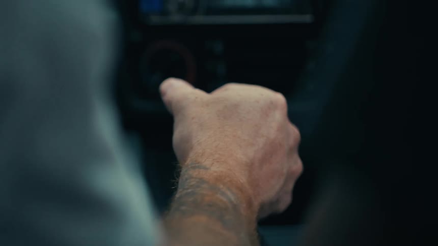 Mans hand positioning the gear of a vehicle