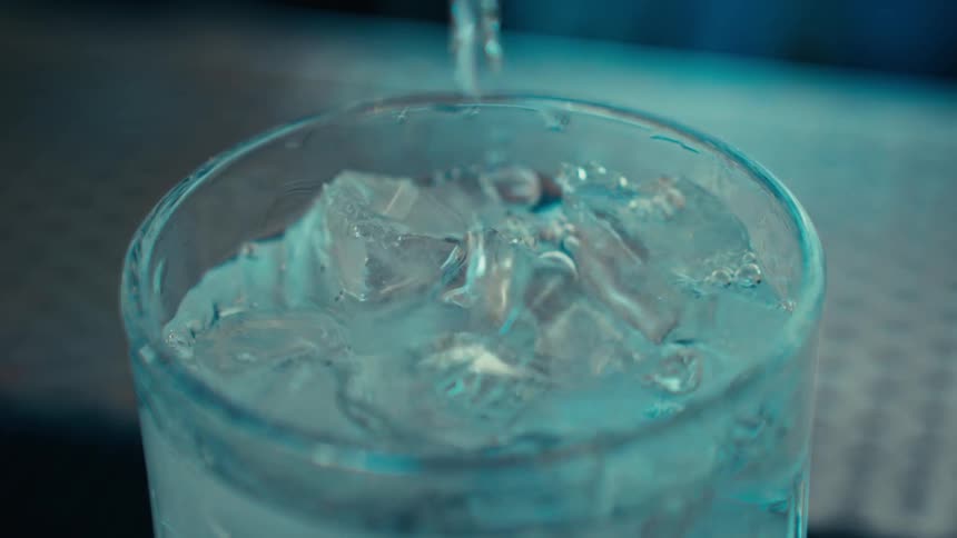 Fluid pours into a cup filled with ice