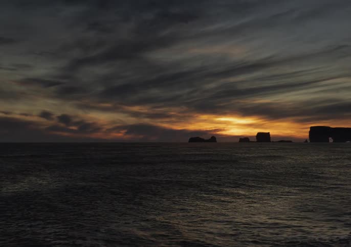 Aerial time lapse of the sunset across the ocean as tide rolls in