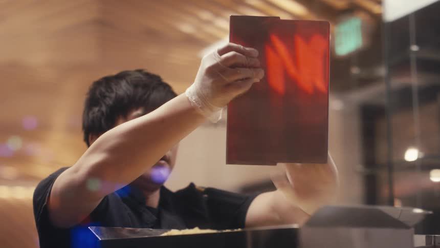 A restaurant worker cleans equipment in a restaurant kitchen