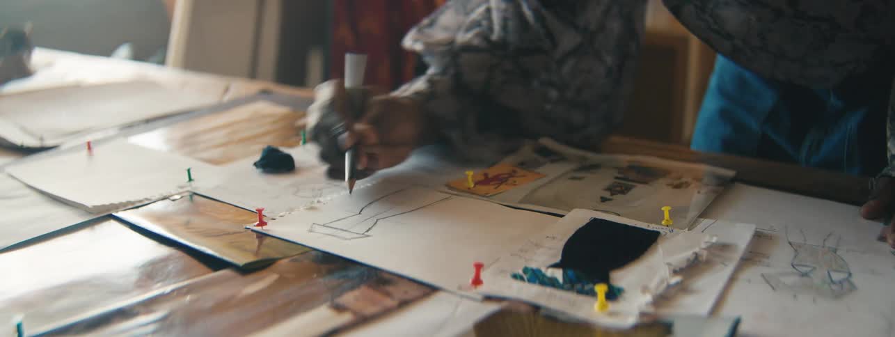 Hand of a fashion designer sketching a dress