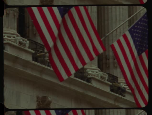 American flags swaying in the breeze from New York Stock Exchange building in Wall Street New York