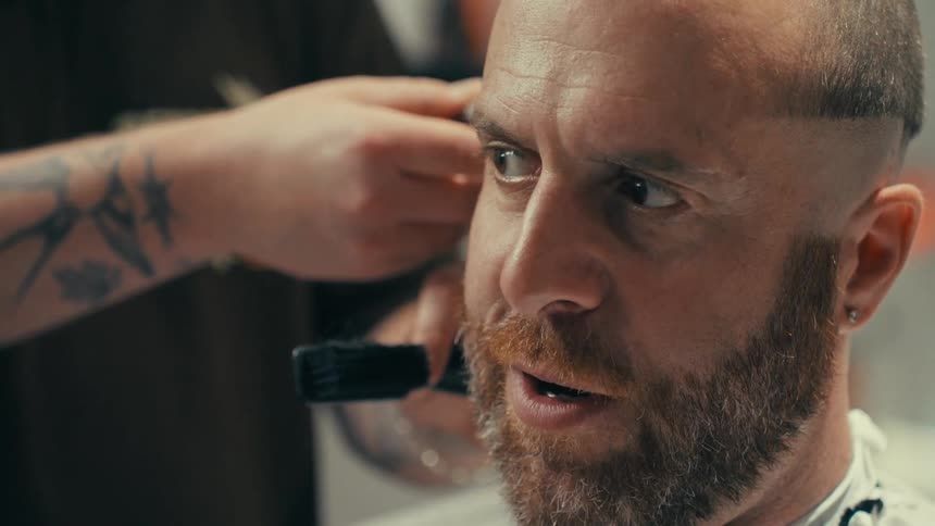 Portrait of a man sitting getting a haircut at a barber shop